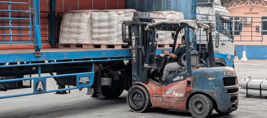 Forklift loading palletized materials into a trailer to support proper trailer weight distribution